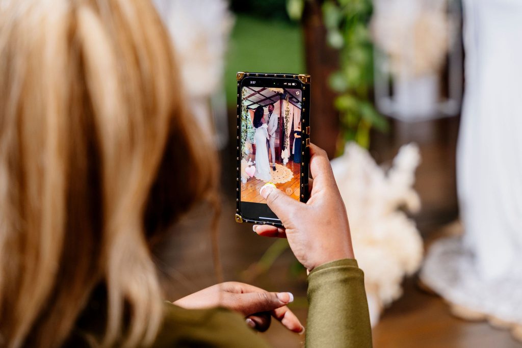 phone friendly elopement wedding with guests holding a phone capturing a video of the ceremony